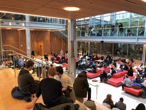 Harvard community members seated listening to a performance in Harvard Commons