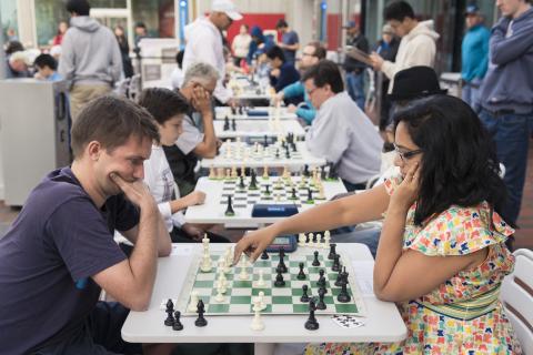 Photo of many people playing games of chess on the Safra Plaza outside the Smith Campus Center